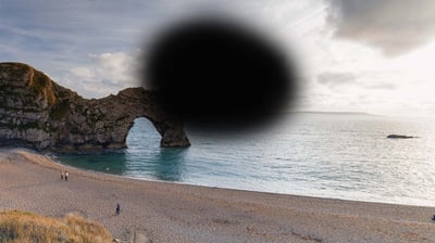 How someone with Macular Degeneration might see the view of Durdle Door - a large, blurred black shape covers the central part of the scene.